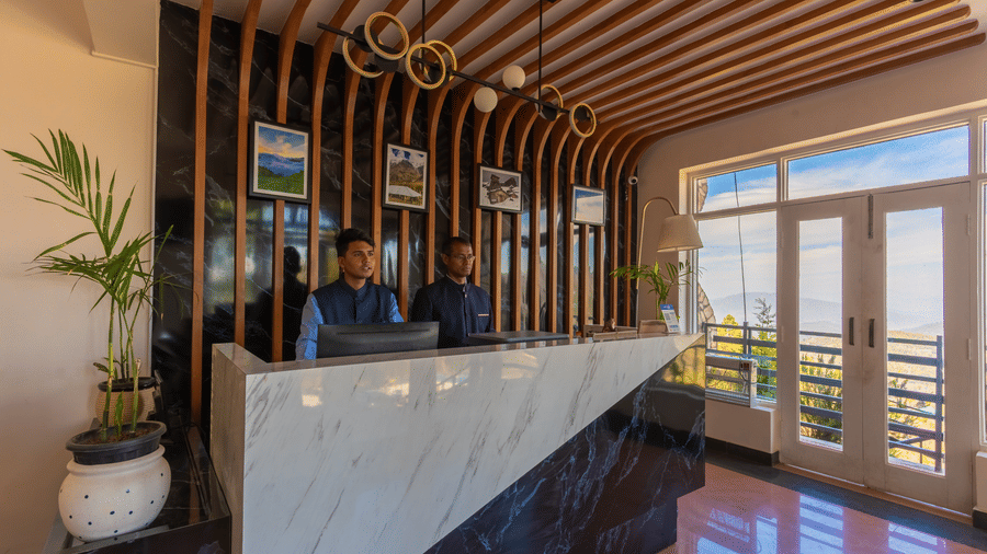 A view of the elegant reception desk with warm wooden paneling at Himalayas Resort By The Lake Hill, Mukteshwar.