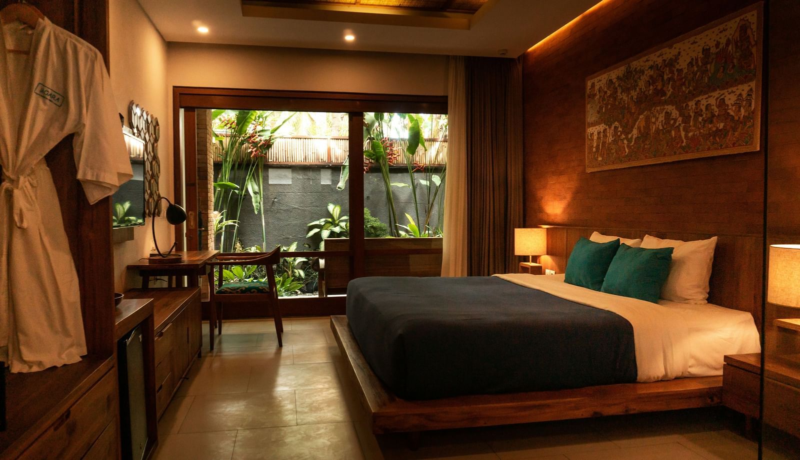 A luxurious hotel bedroom with a large bed, wooden furniture, and warm lighting.
