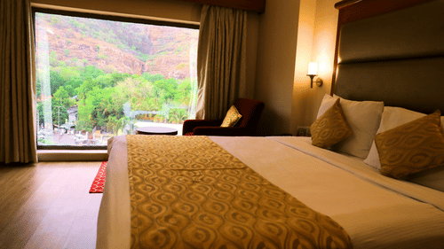 Bedroom with bed, seating area, and view.