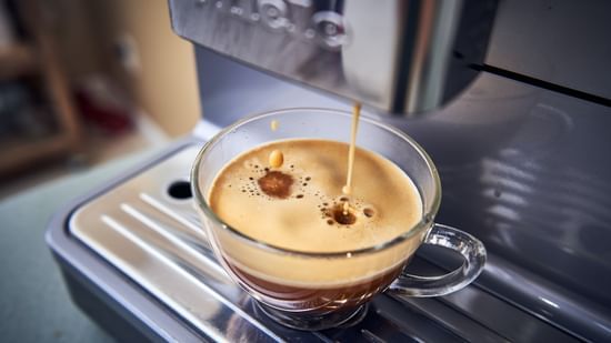 Coffee being poured from a machine into a cup.