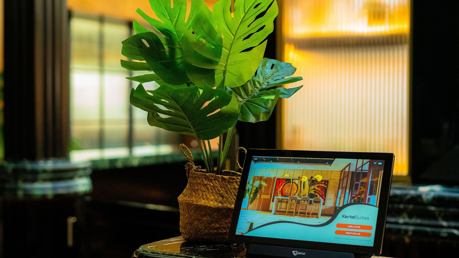 Travel Desk at KertelSuites, featuring a neatly placed iPad and a flower pot on the table