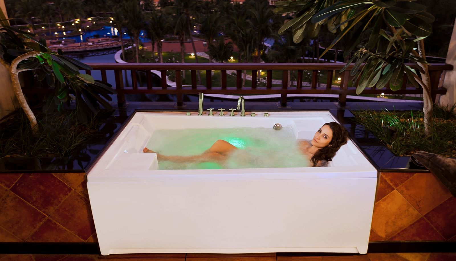 a woman using the sakuzzi inside HEAVENS Category room at Ocean Spray Puducherry