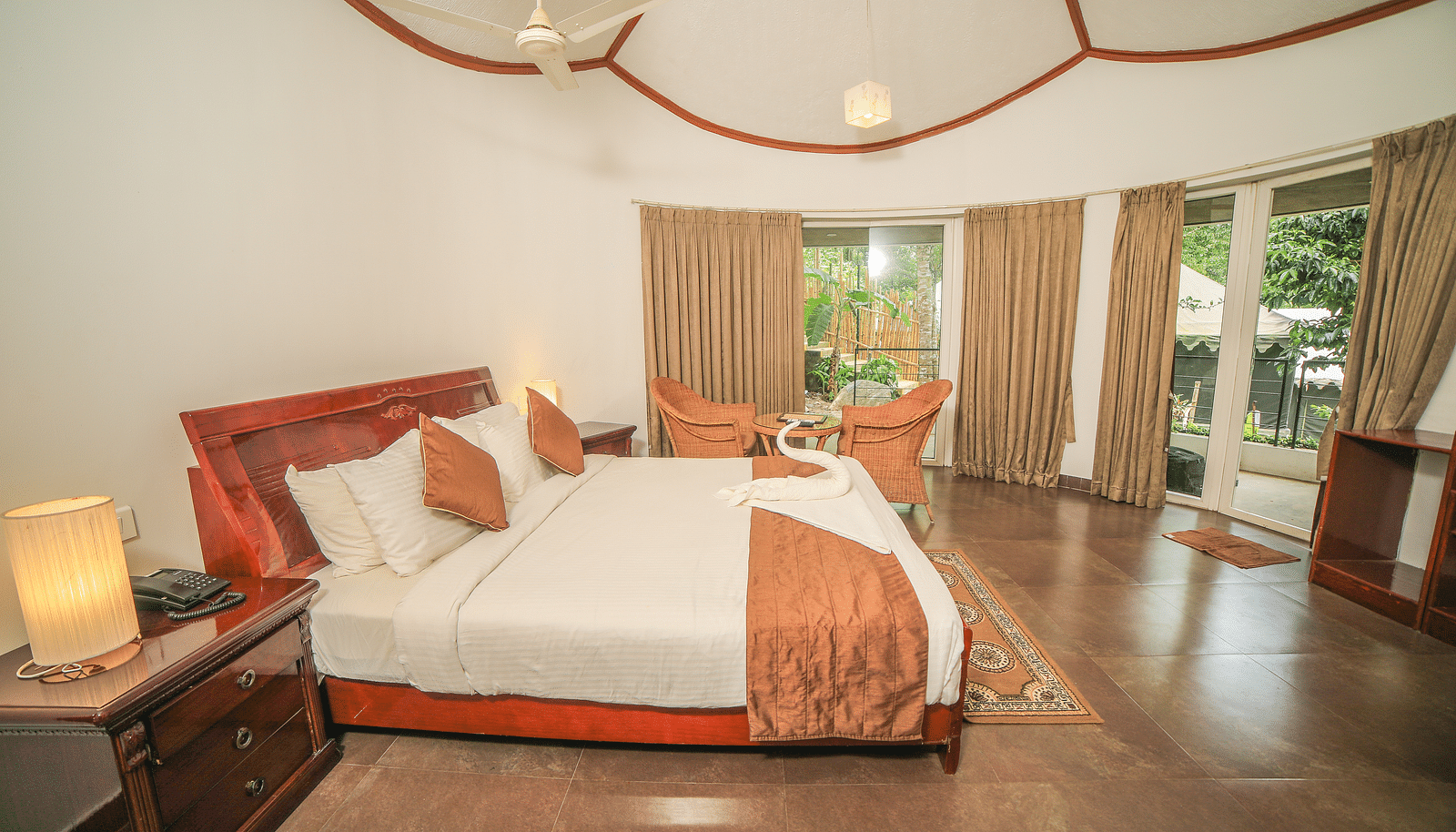 Side view of a room with a bed and a wooden tables beside it at WOW Bison Woods.