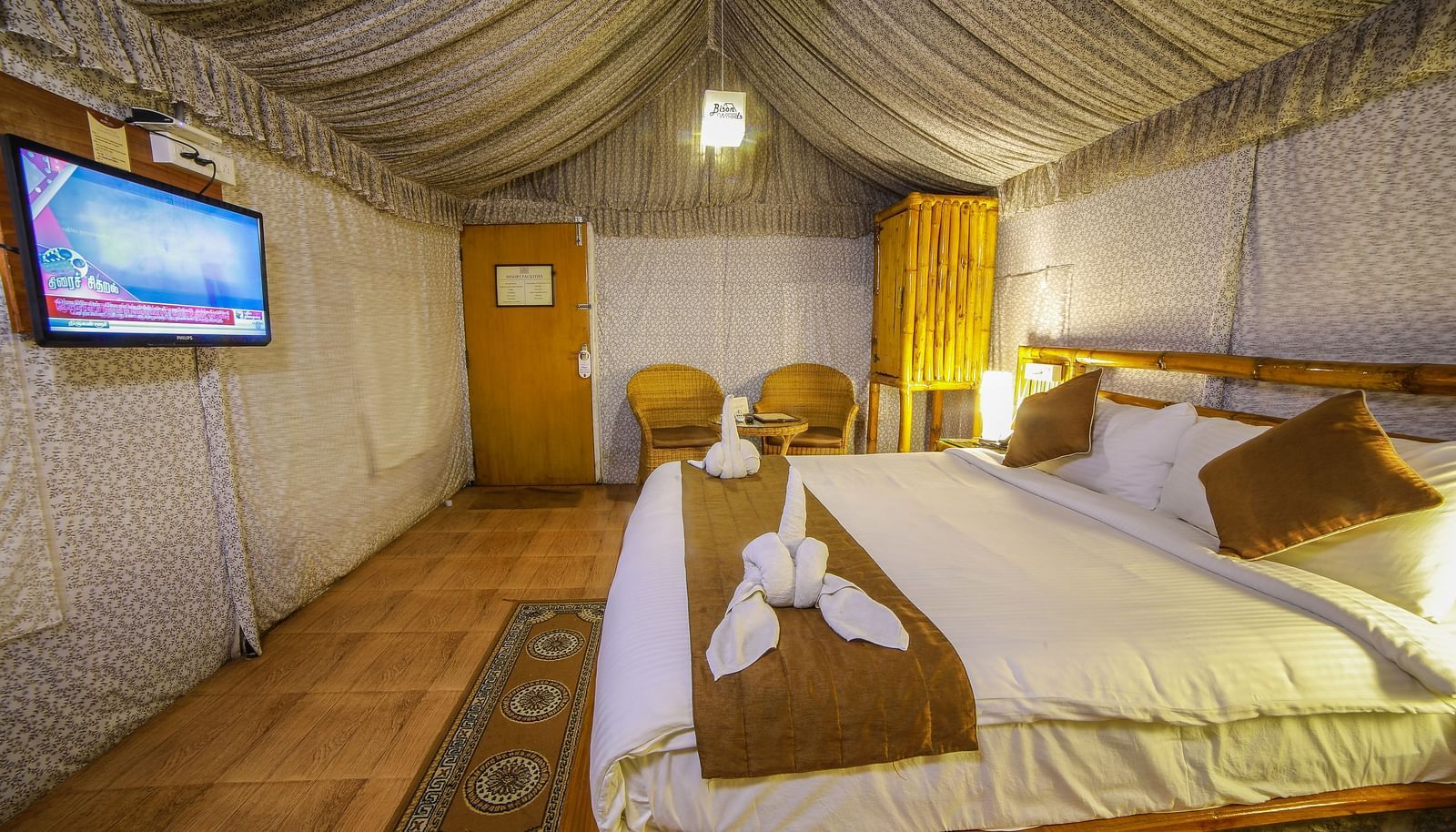 Side view of a room with a bed and a seating area on the side at WOW Bison Woods.