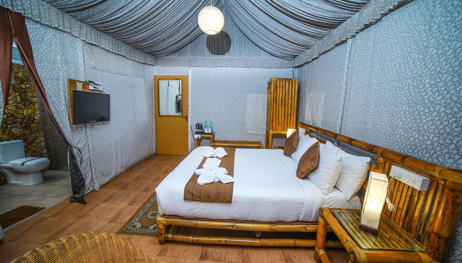 Side view of a room with a bed and a wooden table beside it at WOW Bison Woods.