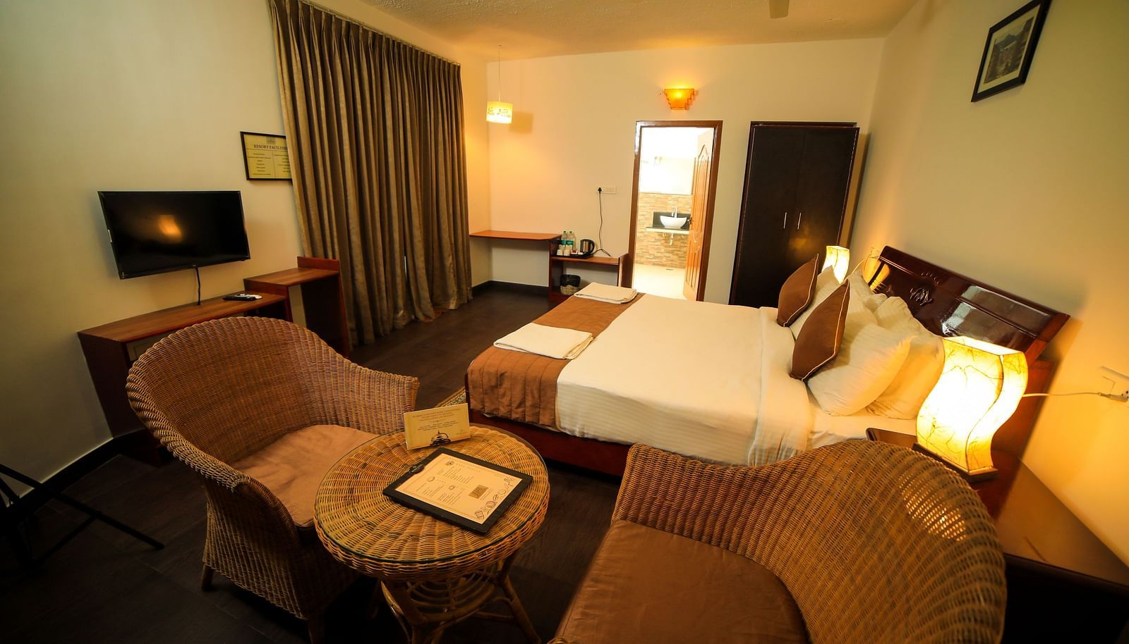 Image of a room with a bed and two chairs with a table on the side at WOW Bison Woods.