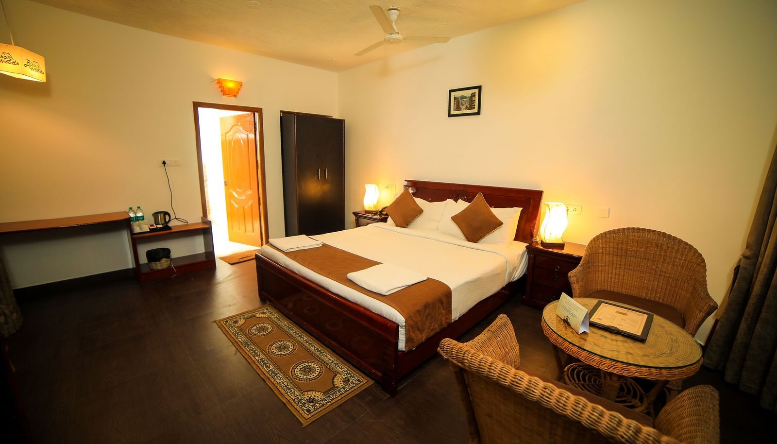 Image of a room with a bed wooden chairs on the side of the bed at WOW Bison Woods.