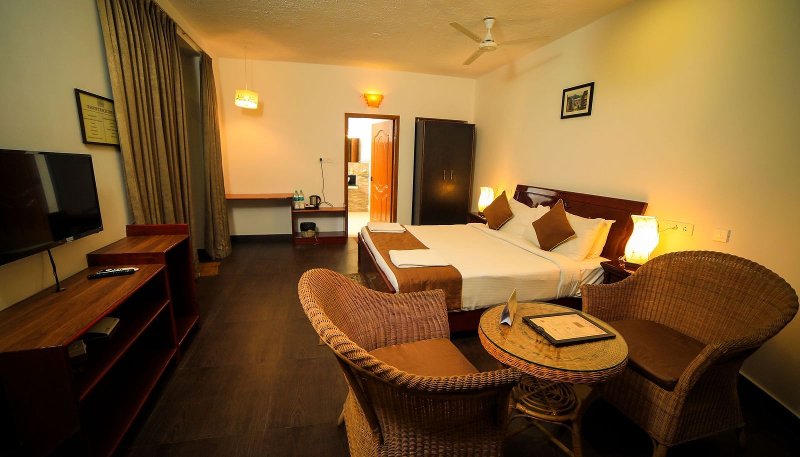 Image of a room with a bed, a television, and a seating area on the side at WOW Bison Woods.