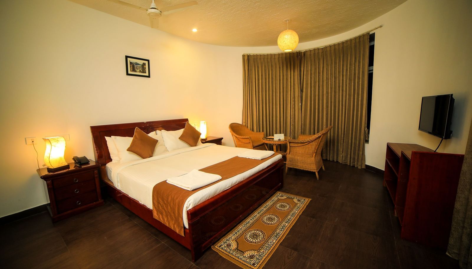 Image of a room with a bed and a ceiling fan above it at WOW Bison Woods.