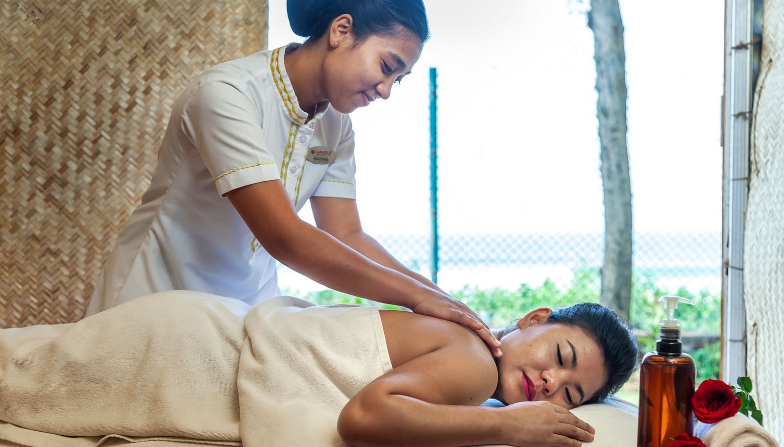 a woman getting a back massage while sleeping on the massage table - Caravela Beach Resort Goa