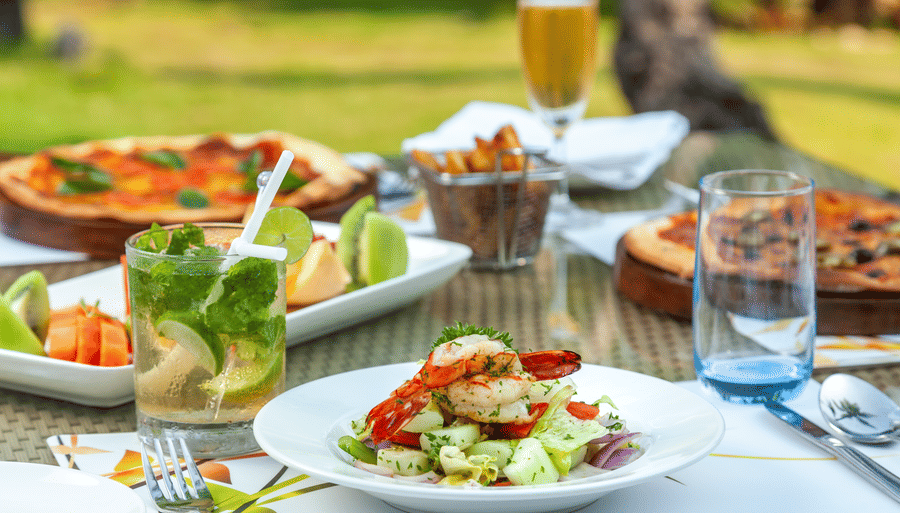many food items kept on the table with beverages - Caravela Beach Resort Goa