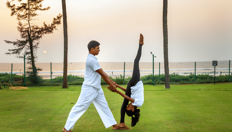 two people doing an asana on the lawn - Caravela Beach Resort Goa