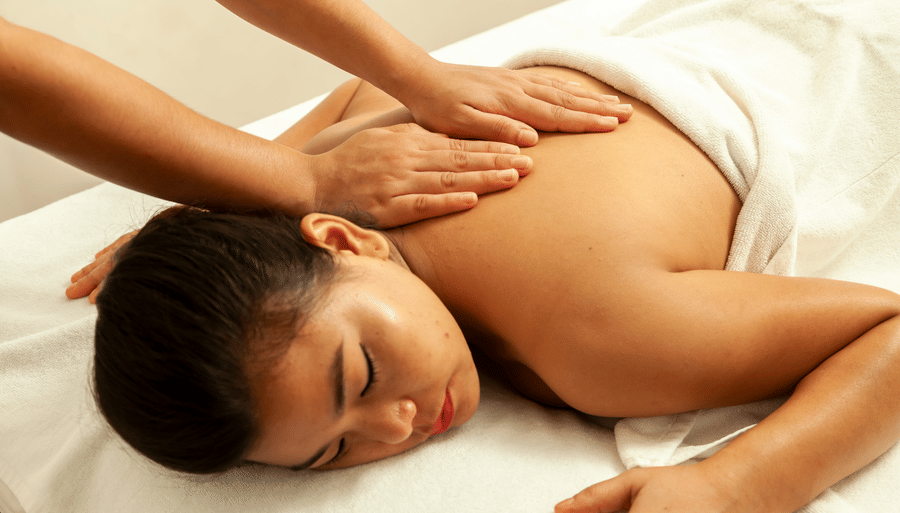 a woman getting a back massage while sleeping on the massage table - Caravela Beach Resort Goa