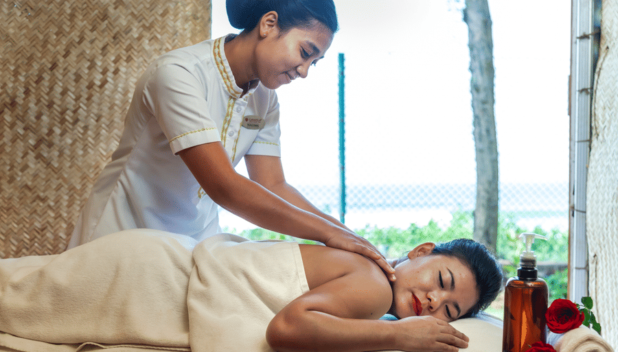 a woman getting a back massage while sleeping on the massage table - Caravela Beach Resort Goa