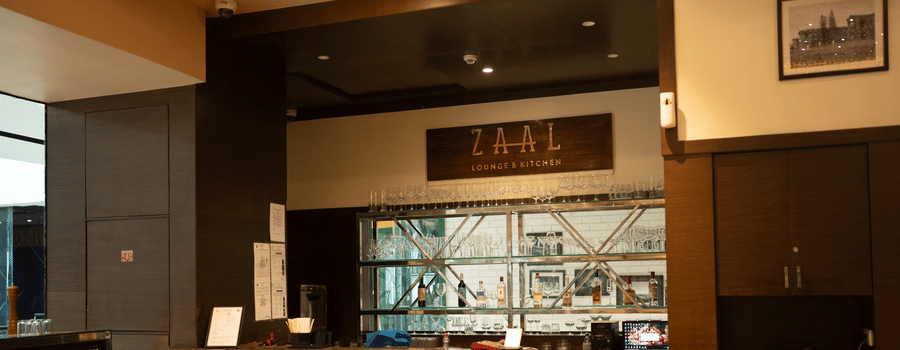 Fine dining interior with bar display and wooden furniture at Zaal Lounge & Kitchen, Whitefield Bengaluru