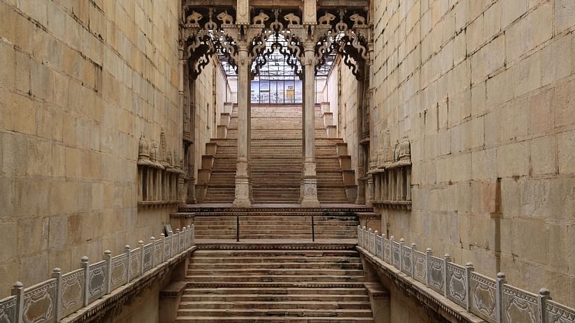 Steps leading up with columns having intricate carvings inside a building in Bundi