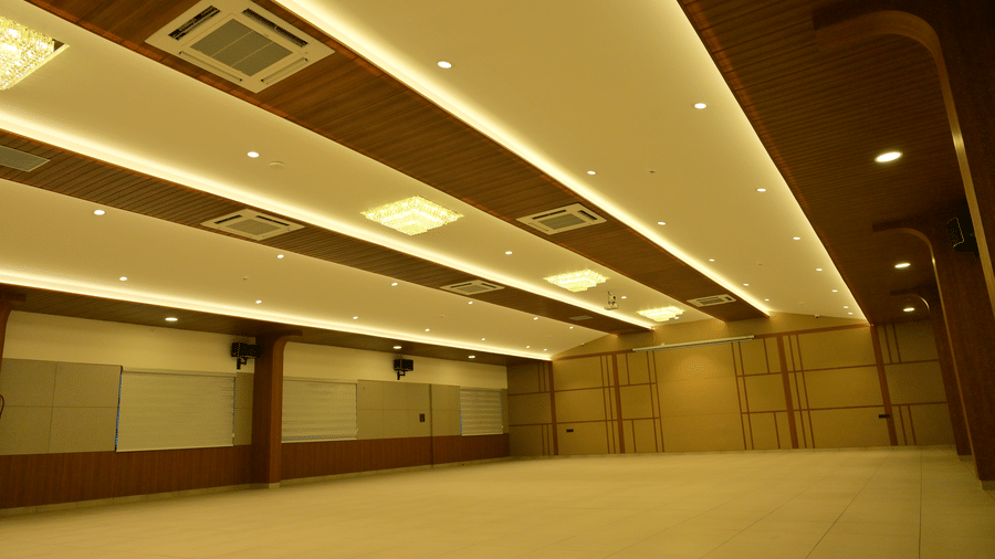 Spacious banquet hall at Bhavanis Vista By Icon Hosur with layered false ceiling, cove lighting, and mirrored side wall.
