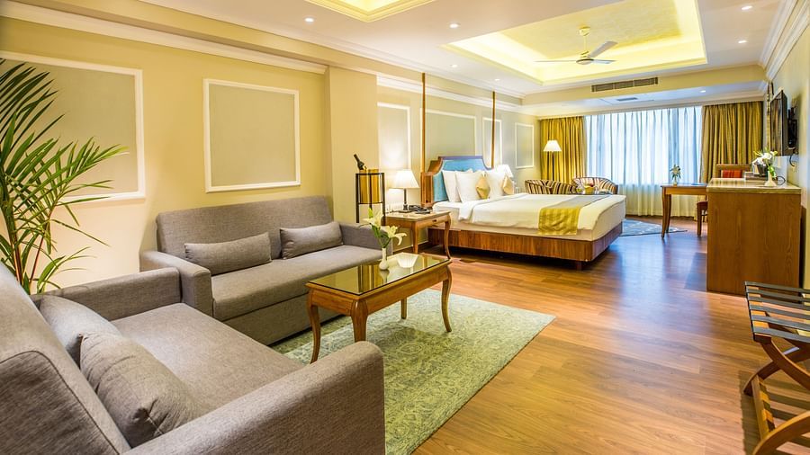 Large sofas and a wooden table are placed on a floor mat, illuminated by warm lighting.