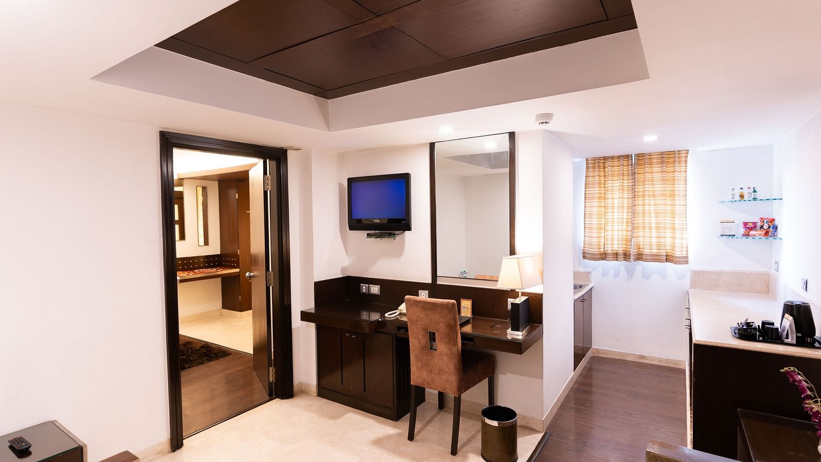 A warm and inviting hotel room with soft lighting and a comfortable bed at The President Hotel, Jayanagar