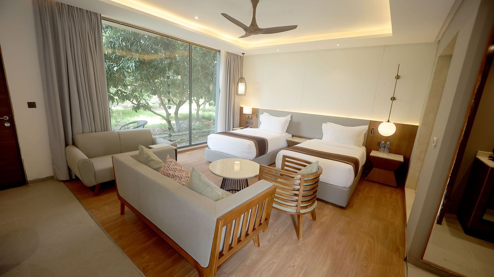 Room with scenic window view, a round white table, and a pair of single beds with matching bedside tables at Wyndham Garden.