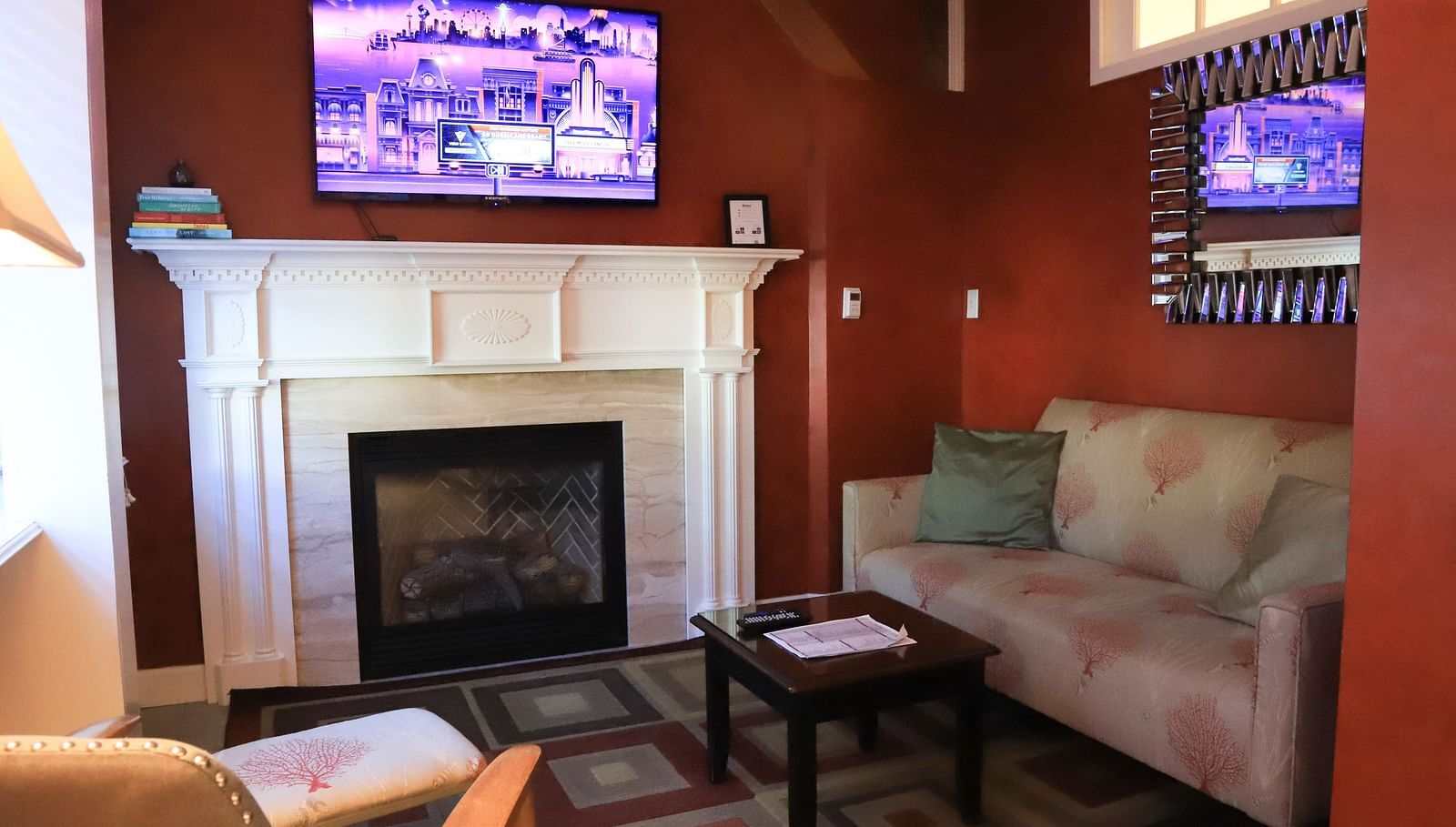 Hotel room with a fireplace, TV, and sofa at Hartstone Inn.