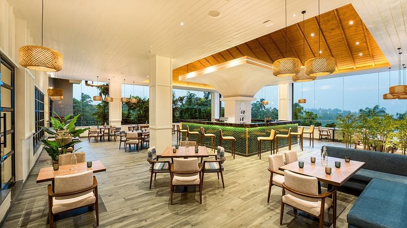 A diagonal view of the rooftop dining area showcases warm lighting and neatly arranged tables and chairs, creating a welcoming ambience for guests at Cloud9 Sarovar Premiere, Palolem Goa