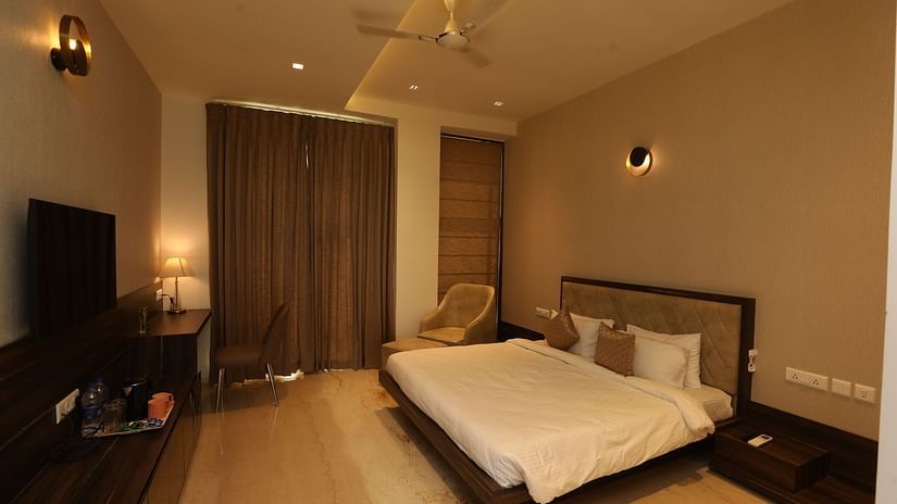 Hotel bedroom interiors with chairs television and a white king size bed