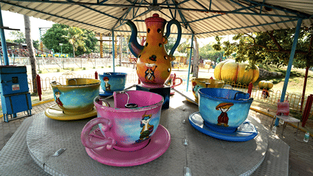 Gracy Cups ride with pink, yellow and blue teacups painted with cartoon cats around a central teapot, under a steel canopy at MGM Dizzee World, Chennai.