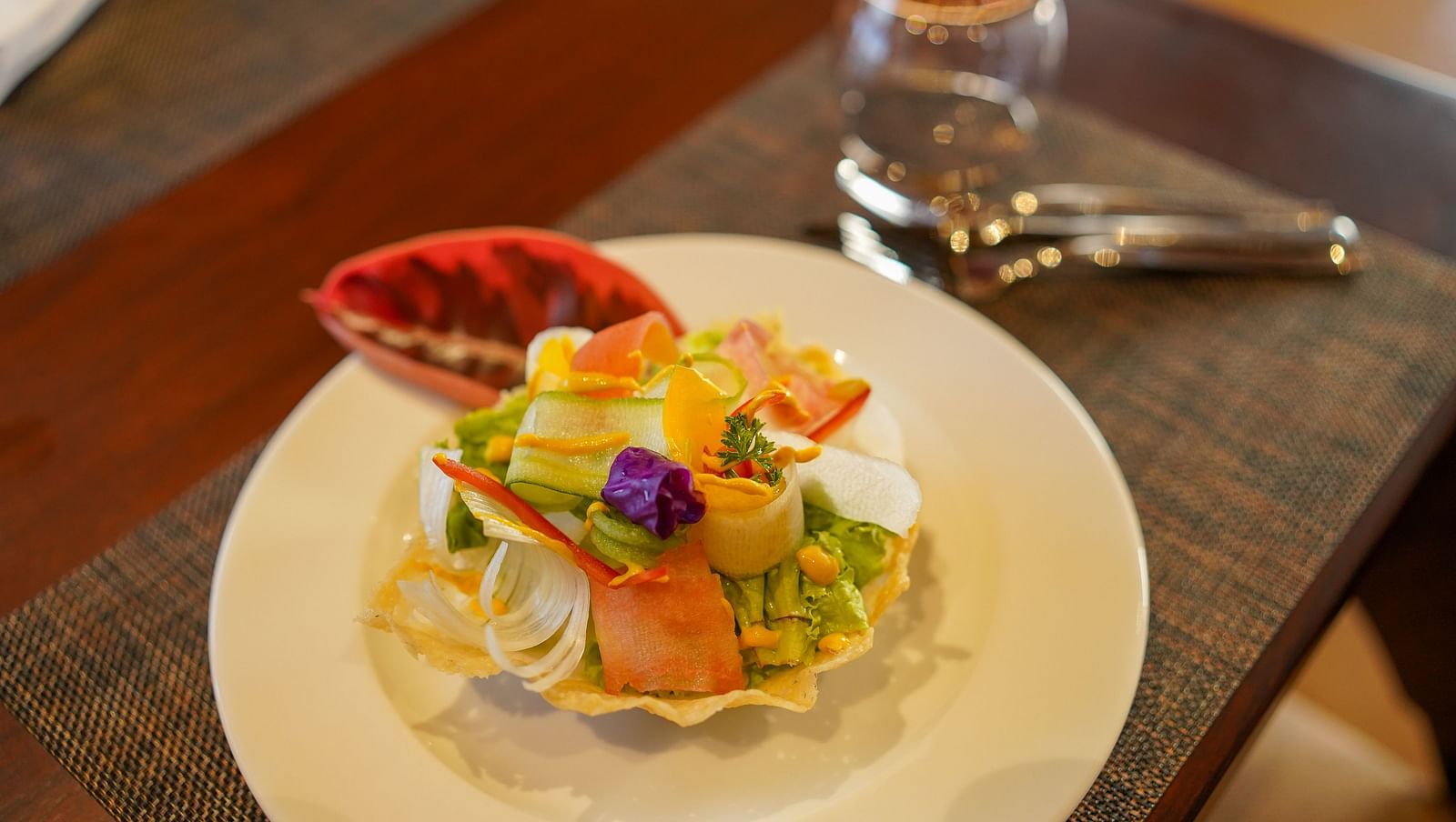 A fresh and colourful salad, beautifully arranged on a plate at Aamaghati Wildlife Resort.