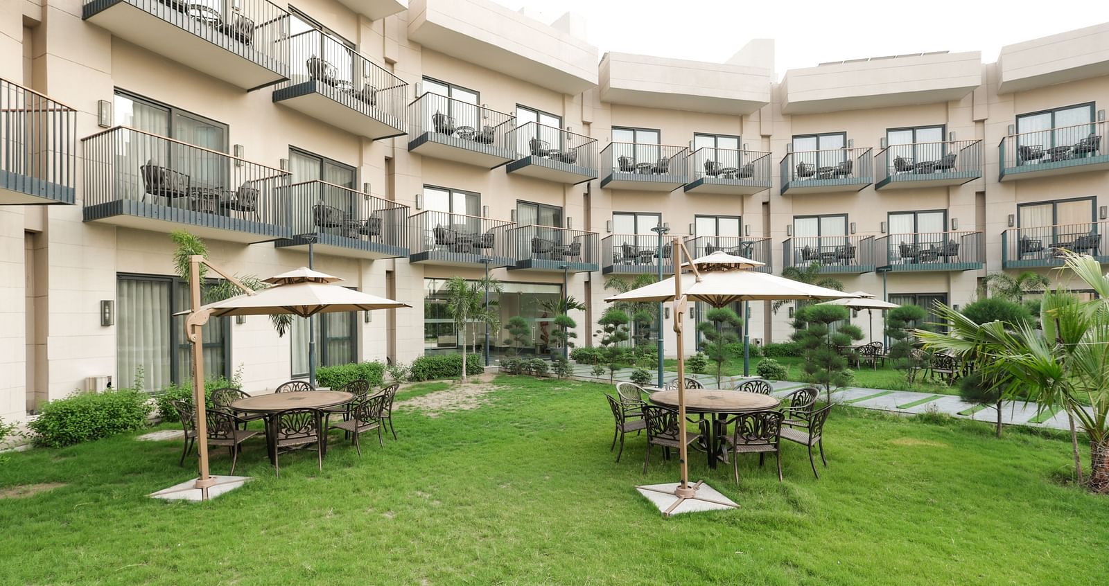 Green garden area with cabana-style seating at Ramada by Wyndham Sonipat Murthal