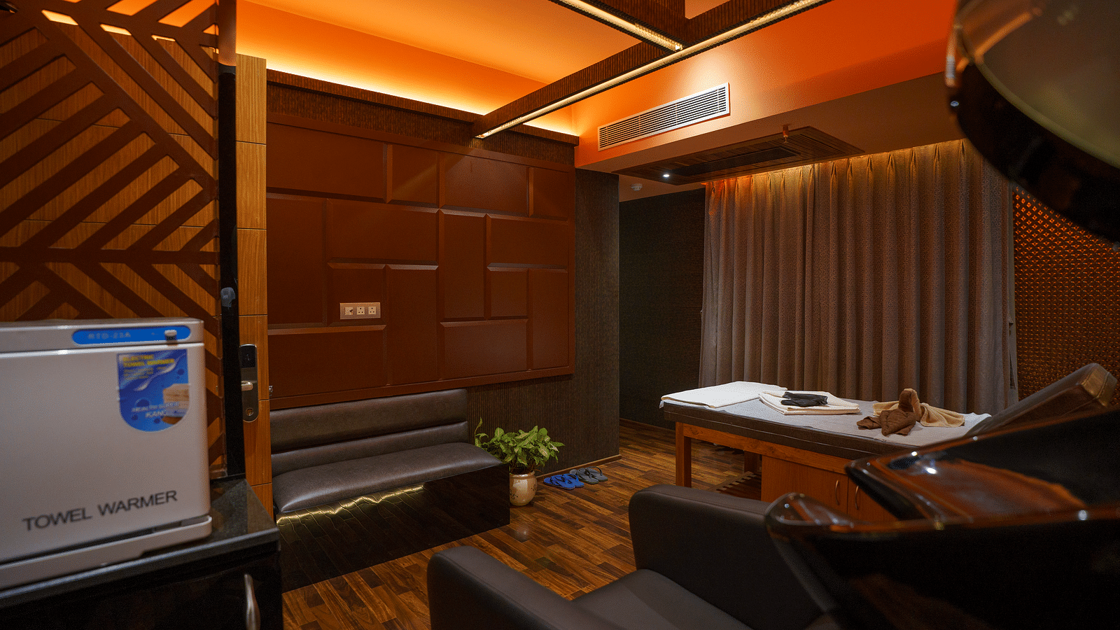 Image of Spa at Coral Reef Hotel & Spa in Port Blair featuring a towel warmer machine and couches along with a massage bed