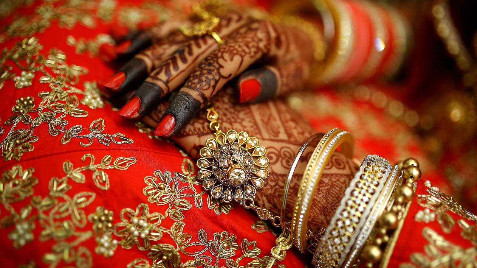 A close up shot of a henna stained hands with bangles
