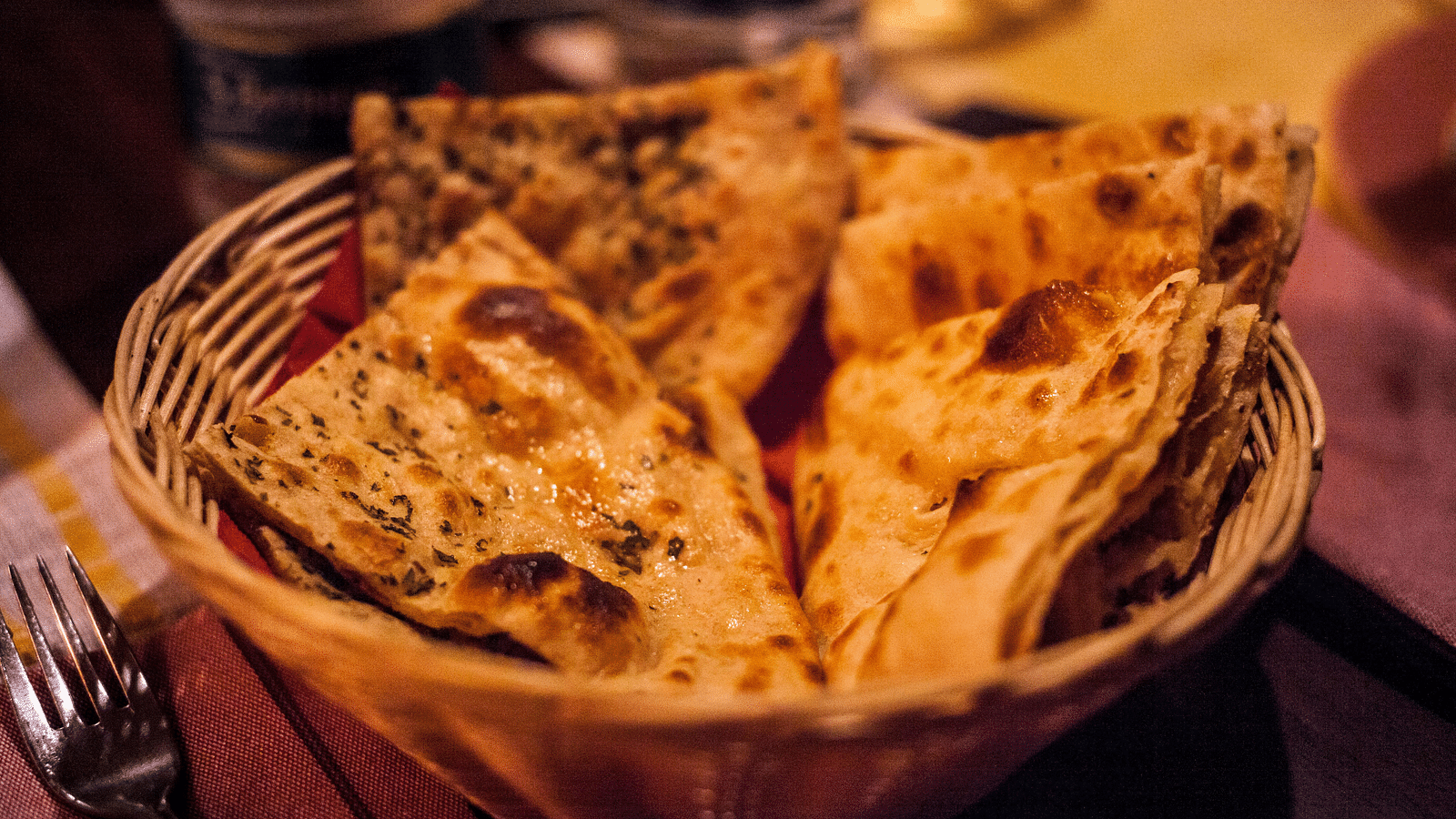 image of naan served in a basket made of wooden straws