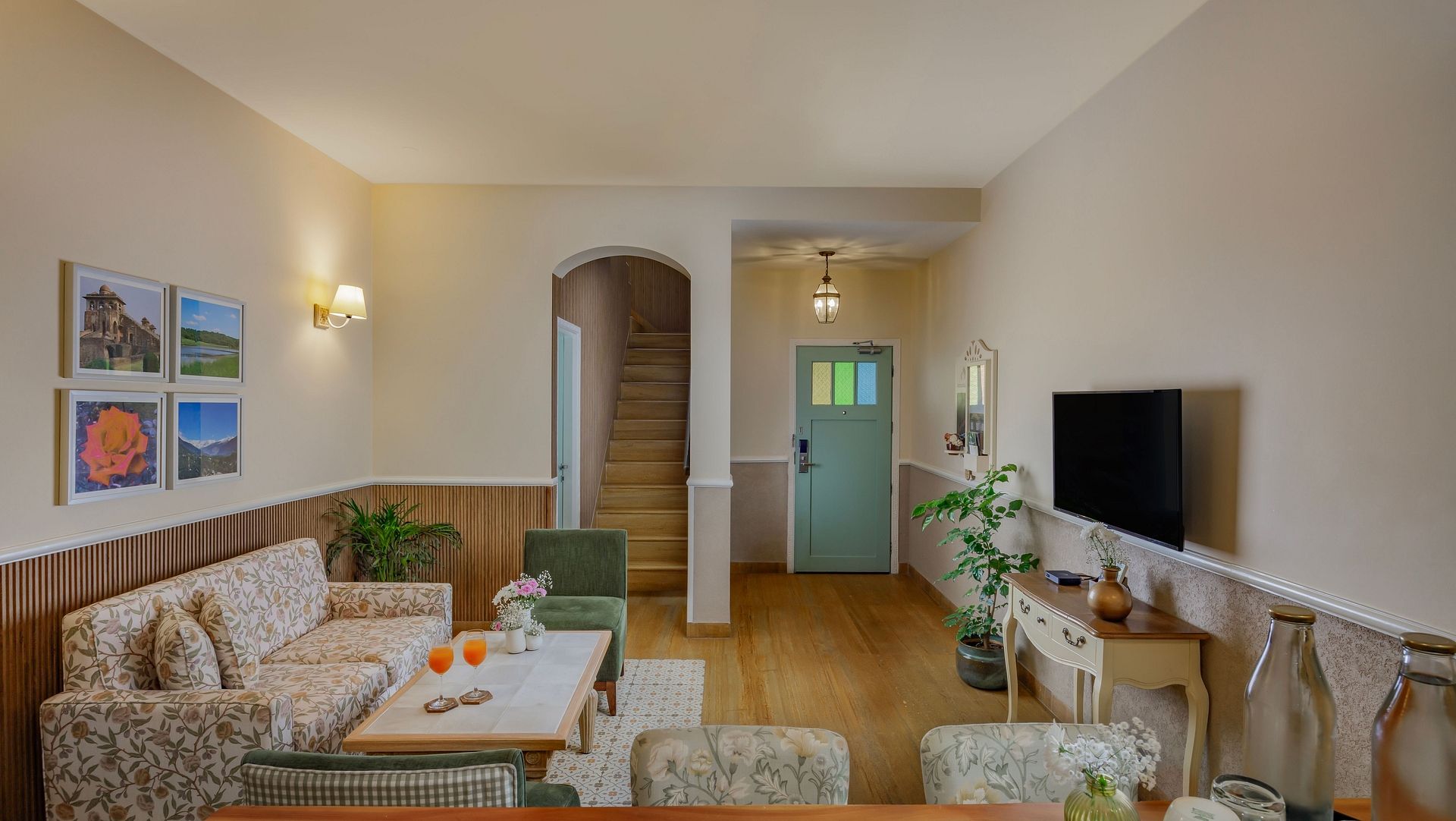 A lounge area at Karma Chalets with multiple sofas, chairs, a TV, and a central wooden table.