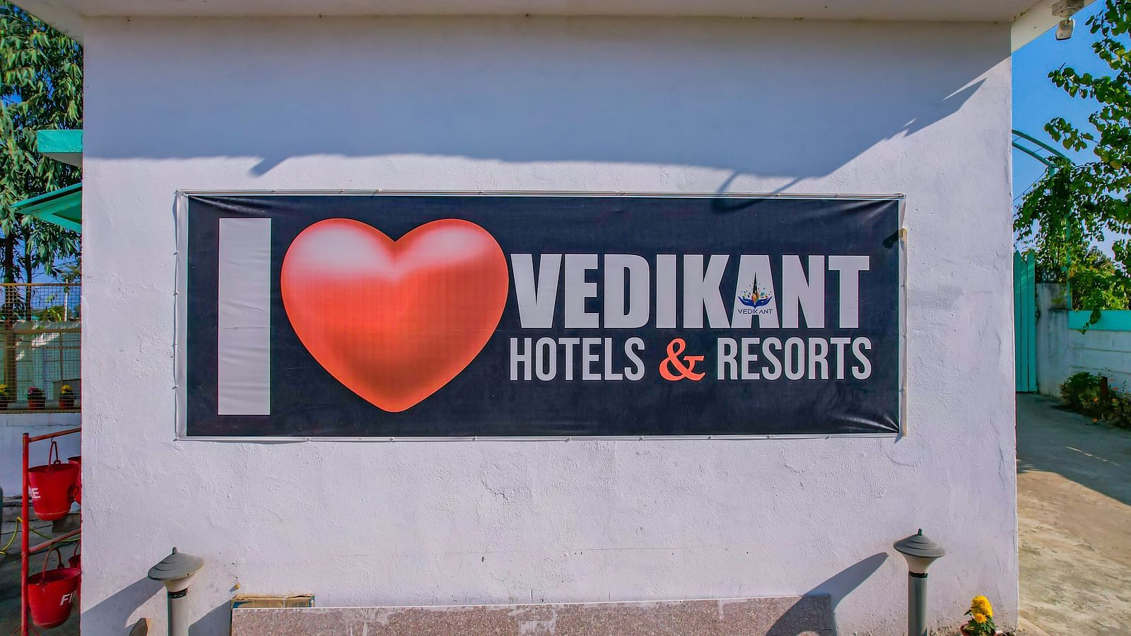 A large wall at Vedikant Resorts The Mallard Corbett featuring the 'I Love Vedikant Hotels & Resorts' signage with a paved area in front.