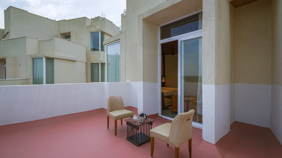 Private hotel terrace with outdoor chairs and a table overlooking the surrounding buildings.