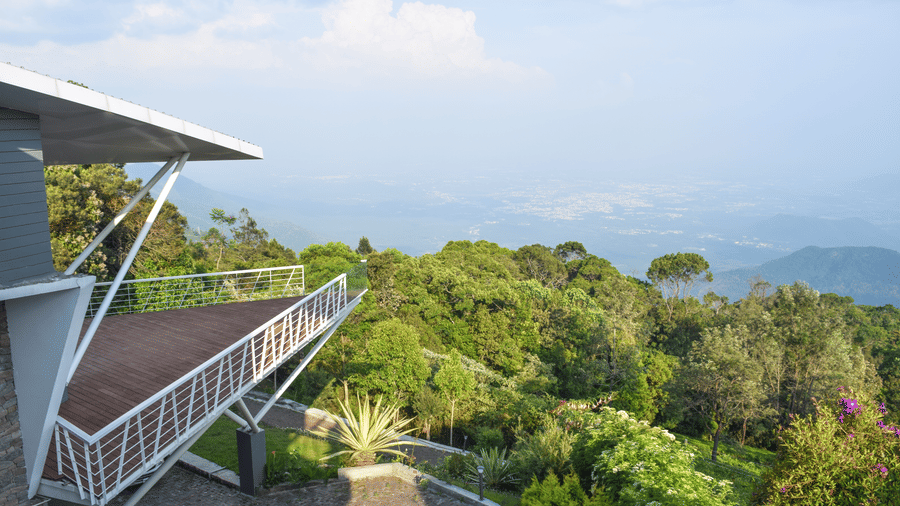 Spacious balcony offering a view of a bright, cloudy sky and distant horizon at Ibex Resorts, Coonoor (Tapas).