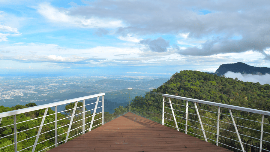  Spacious living area with panoramic windows offering a view of a bright, cloudy sky and distant horizon at Ibex Resorts, Coonoor (Tapas).