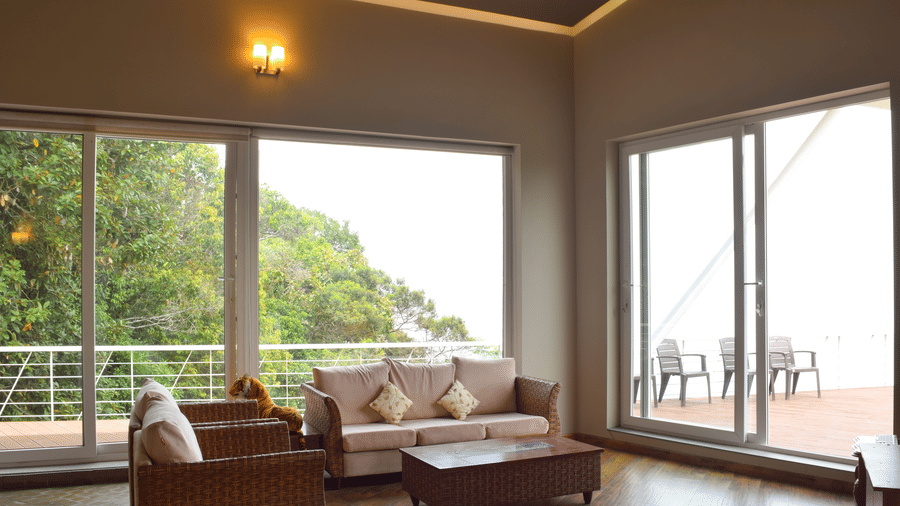 View of indoor lounge with seating area, french windows, cosy setting and wooden flooring at Ibex Resorts, Coonoor (Tapas).