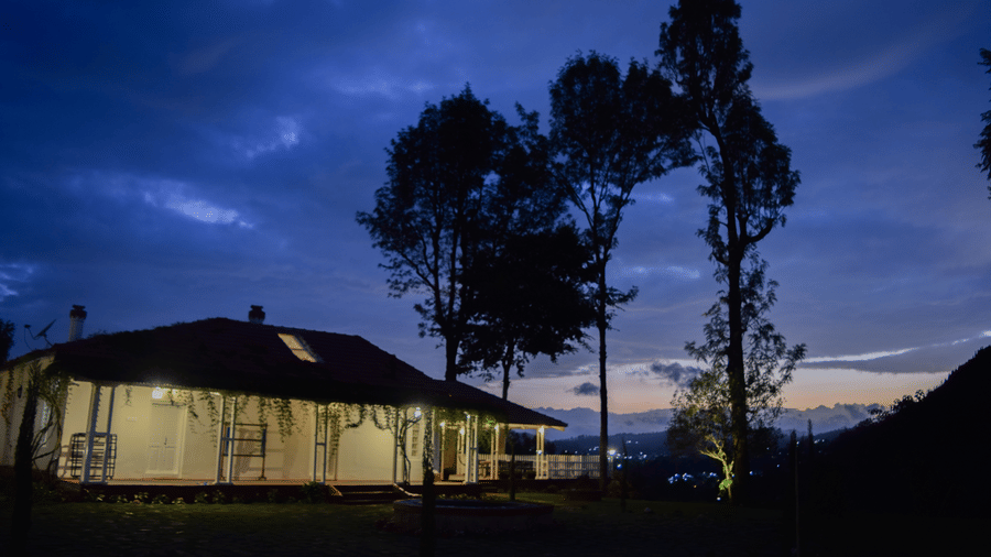 A cottage surrounded by foliage overlooking the dark sky - Ibex Resort, Coonoor (Leewood).
