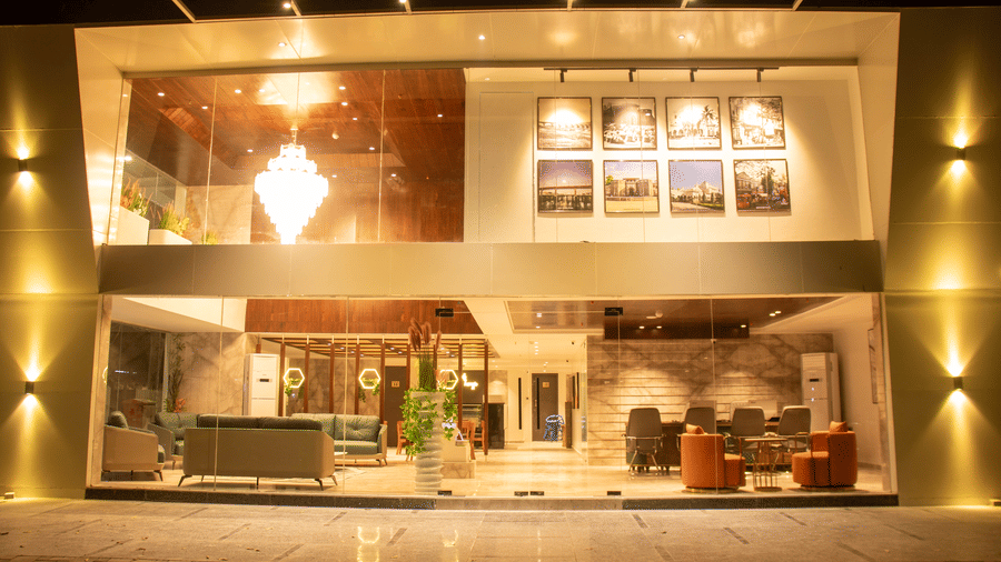 The exterior view of illuminated hotel entrance and glass facade at Magnus Lxia Premier, Kalyani Nagar.