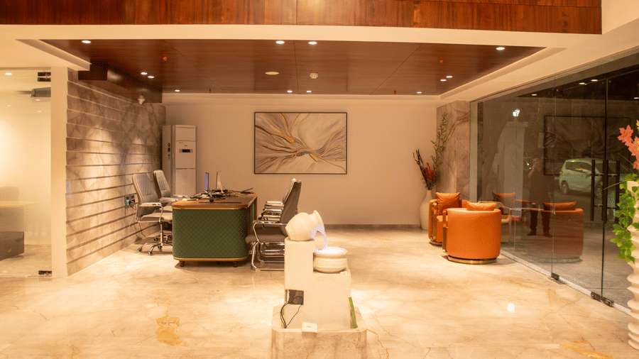 The lobby area with 2 armchairs, reception desk, chairs, and marble sculpture at Magnus Lxia Premier, Kalyani Nagar.