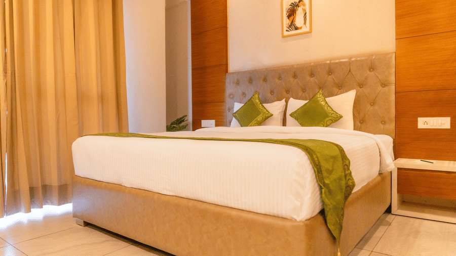 A large bed in a Deluxe Room at Montclair Ananta, Elite.