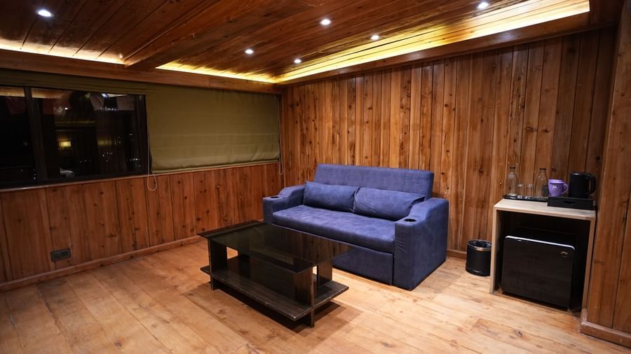 Spacious wooden room with a sofa, coffee table, and mountain view