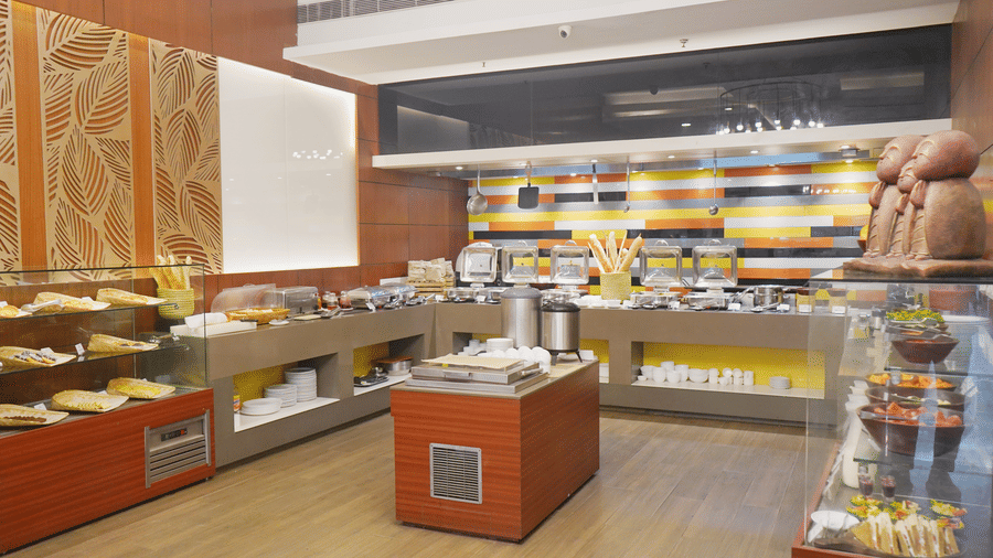 A side angle view of buffet counter at Nemesia restaurant featuring a variety of desserts.