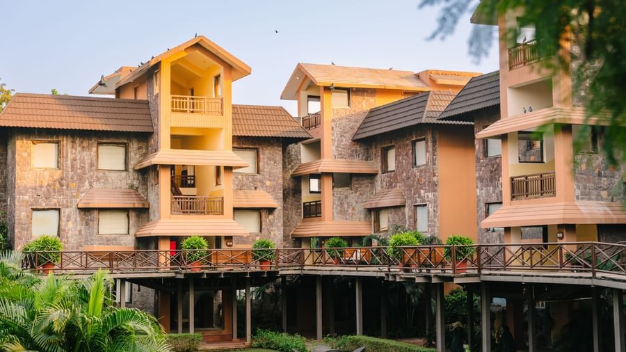 Facade of The Baagh Ananta Elite, Ranthambore, with a front lawn area featuring a coffee table and chairs