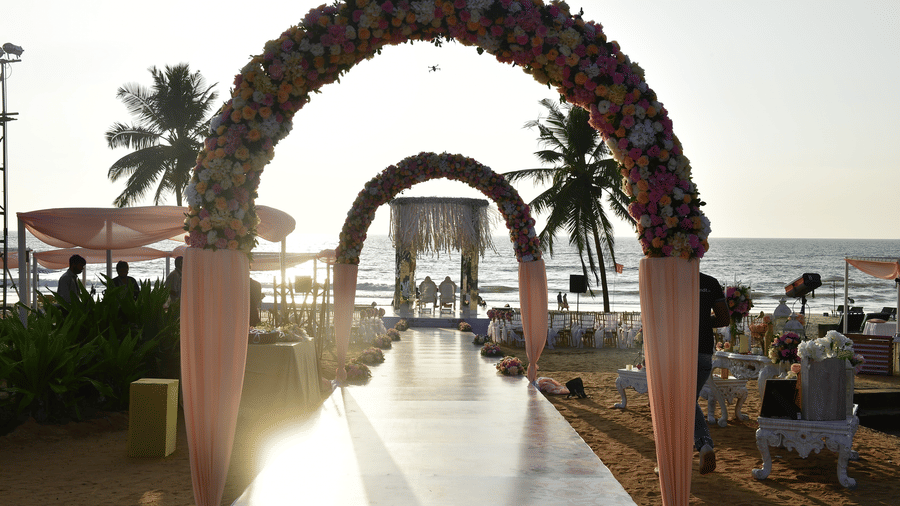 Archways leading to beach decorated with flowers for your destination wedding venue in goa