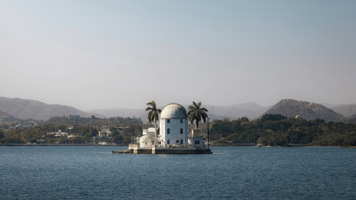 Udaipur Solar Observatory on island in Fateh Sagar Lake Udaipur surrounded by calm waters and distant Aravalli hills under clear sky