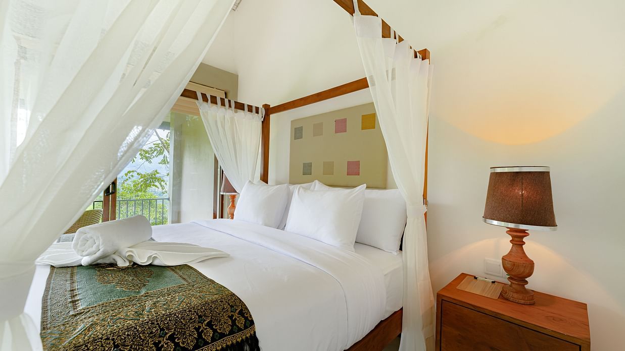 An image of our spacious room with comfortable bed and a night lamp