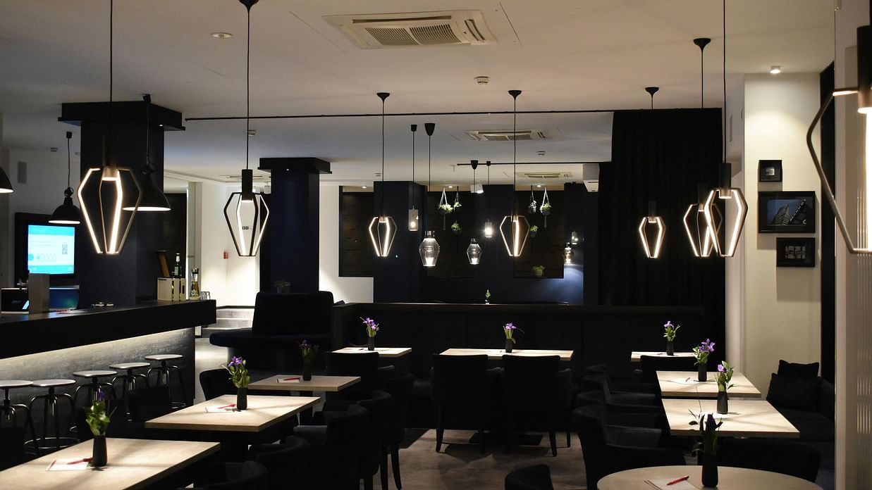 A modern, dimly lit cafe or lounge interior with comfortable seating and contemporary decor.